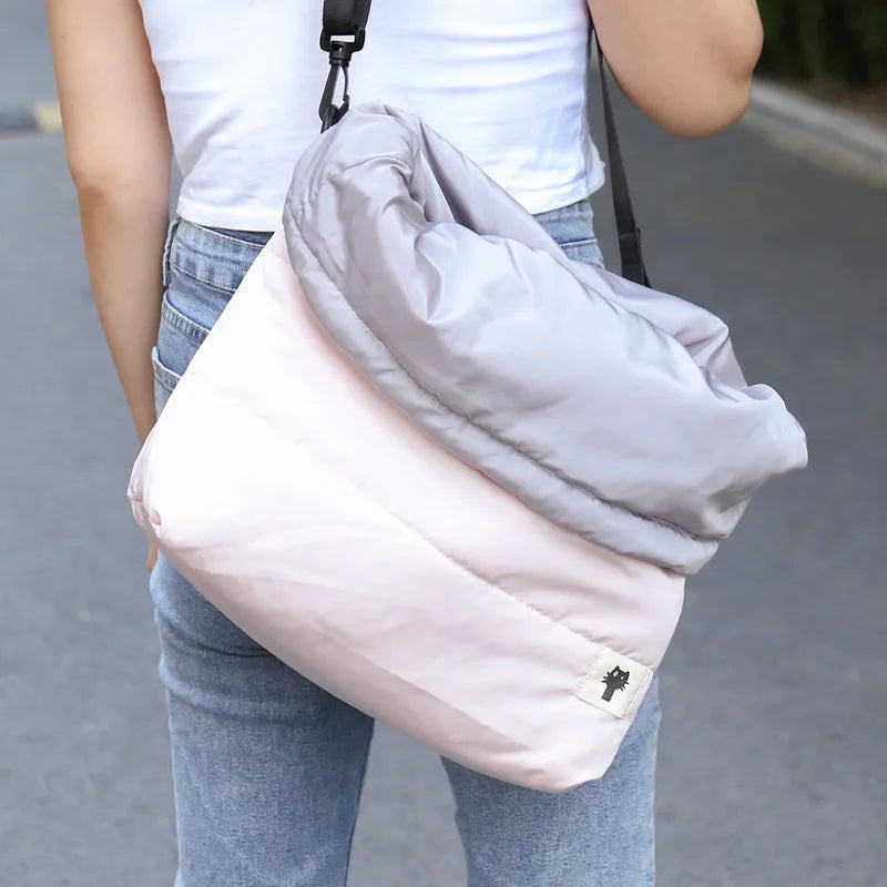 Person holding a light gray and pink bag with a blurred background