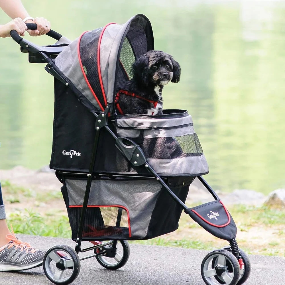 Dog in a pet stroller being pushed outdoors with a blurred natural background
