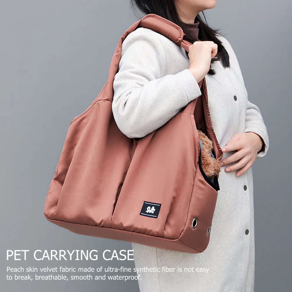 Person holding a pink pet carrying case with a gray background