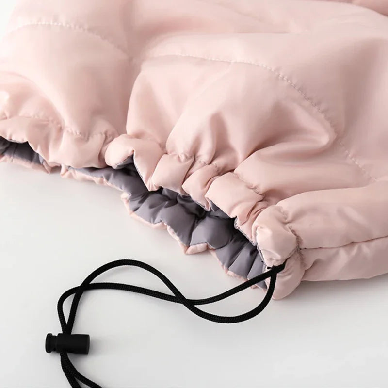 Close-up of a pink and gray quilted product with a drawstring on a light background