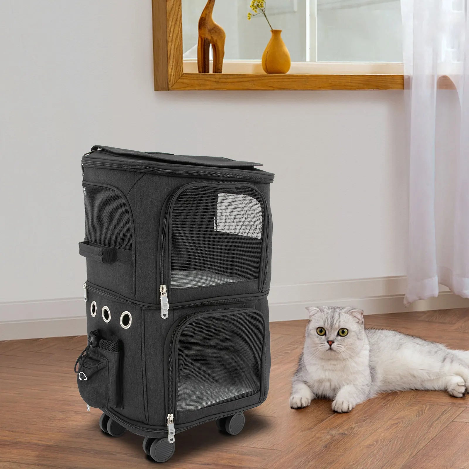 Black pet carrier with wheels on a wooden floor, accompanied by a white cat.