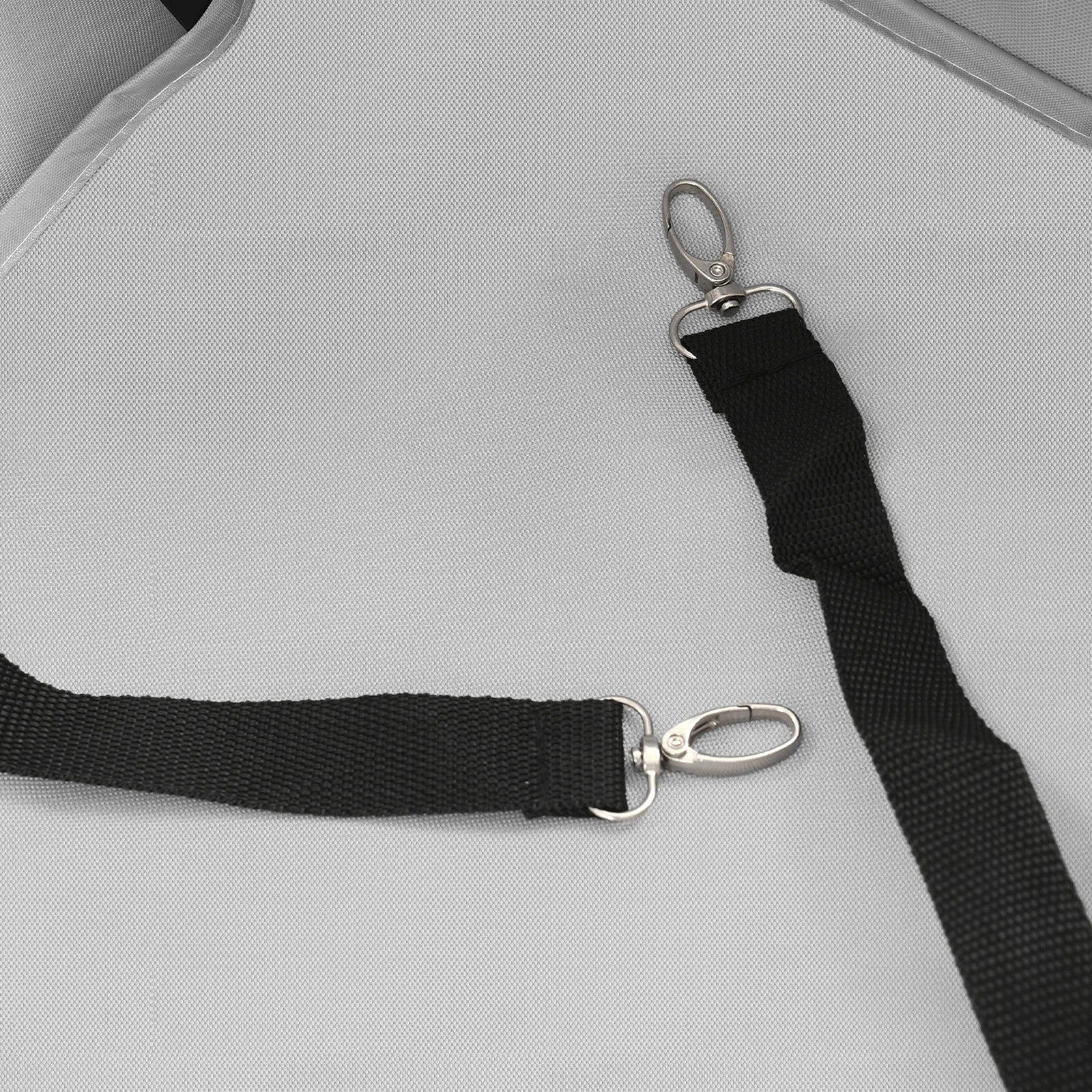 Close-up of a black strap with silver clasp on a gray surface
