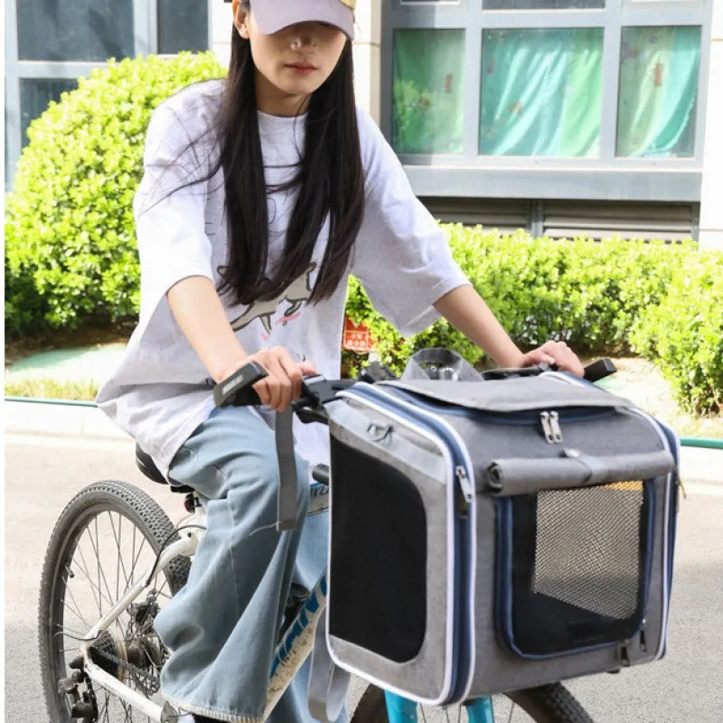 Person riding a bicycle with a pet carrier attached