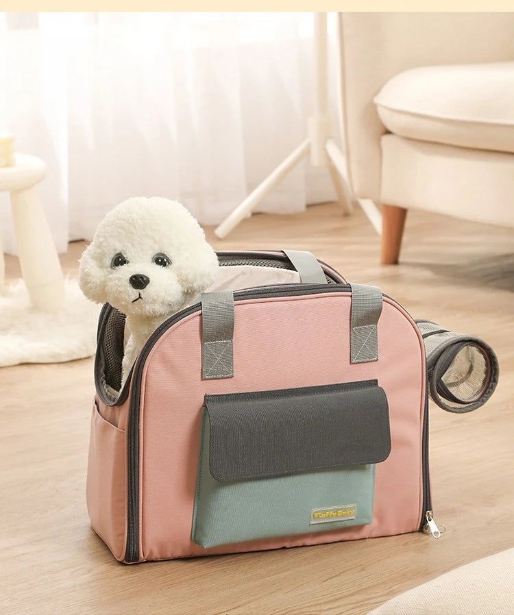 Small white dog inside a pink and gray pet carrier on a wooden floor.
