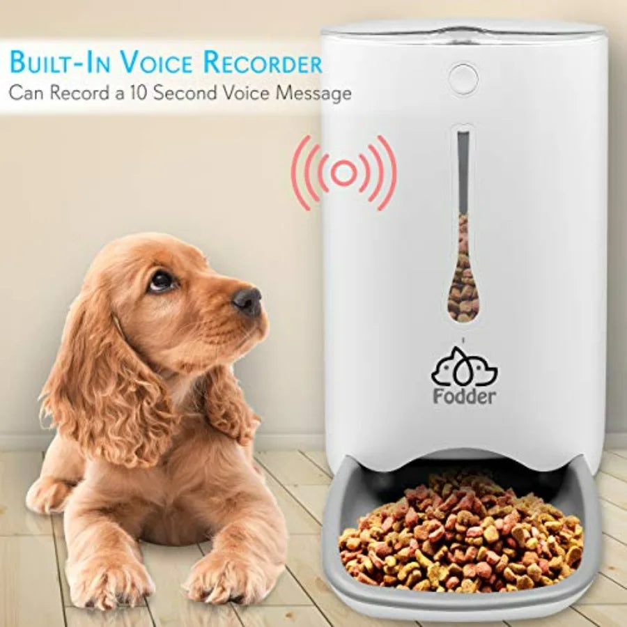 Pet food dispenser with a built-in voice recorder and a dog sitting next to it.