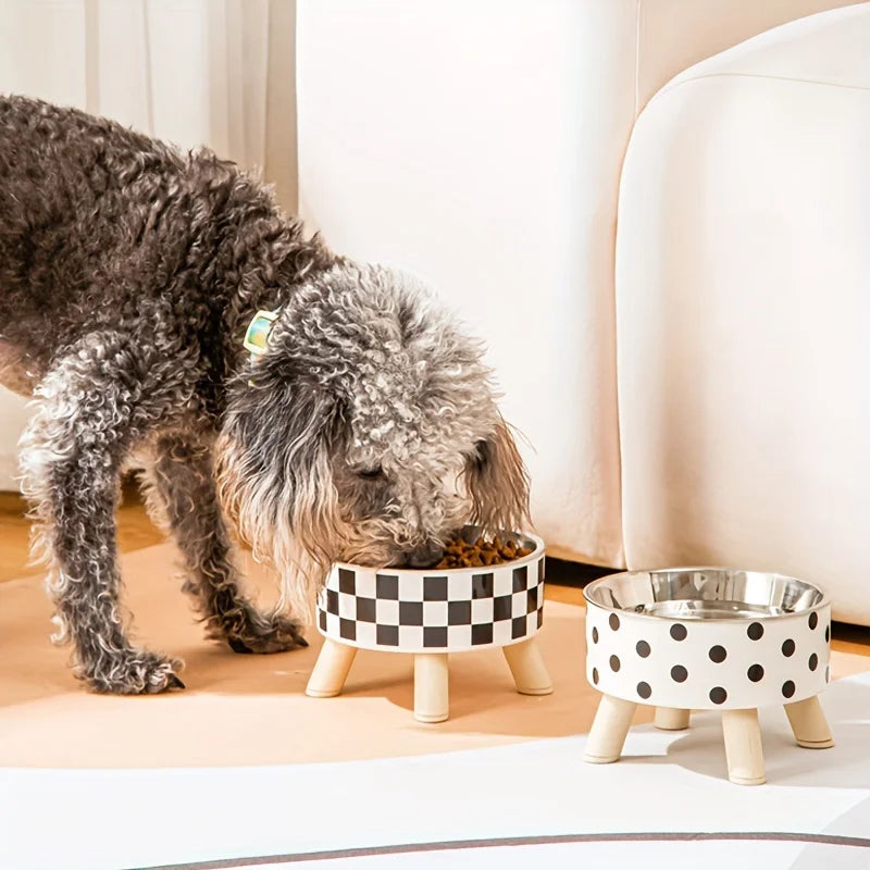 Dog eating from a checkered pet bowl on a wooden floor.