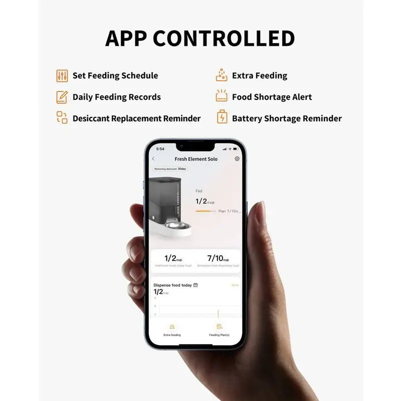 Hand holding a smartphone displaying an app with app-controlled features for a pet feeder.